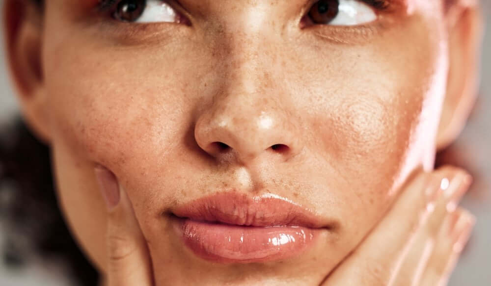 Close-up of a woman with moisturized, healthy skin and natural, soft lips, showcasing a radiant complexion.