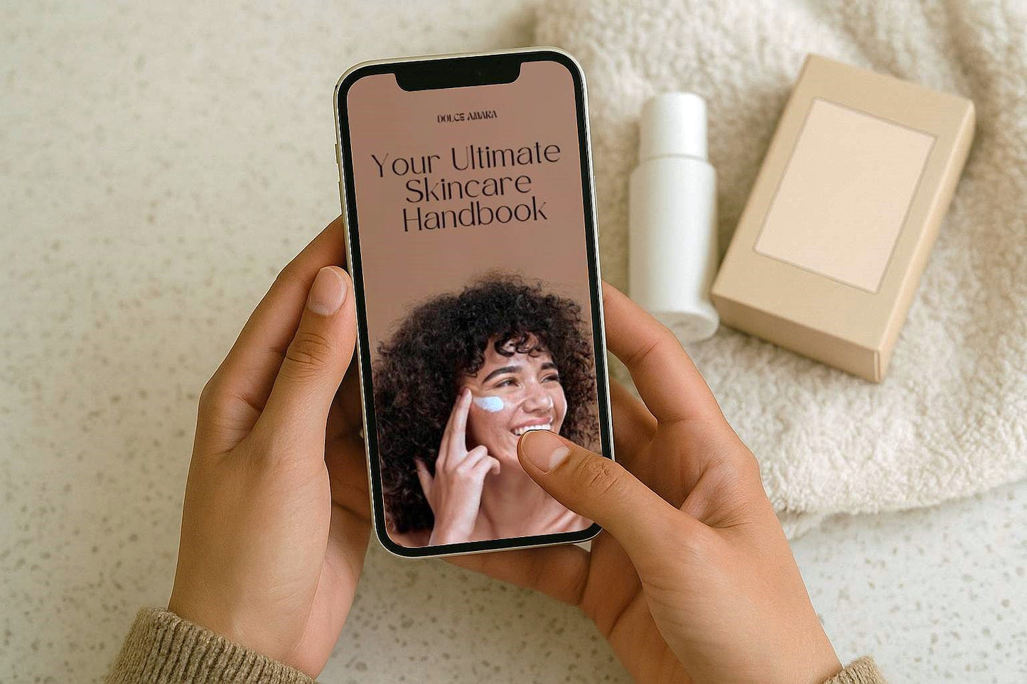 Woman holding phone displaying digital skincare handbook cover with smiling model, surrounded by skincare products on a towel background.